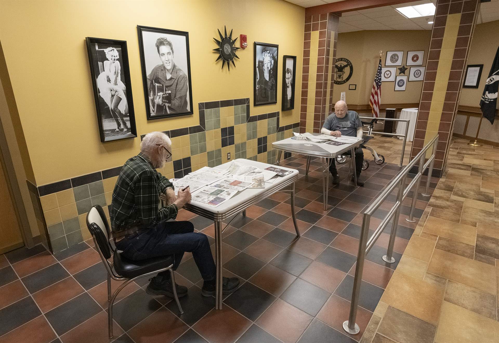 North Dakota Veterans Home residents reading newspapers in the reading area.