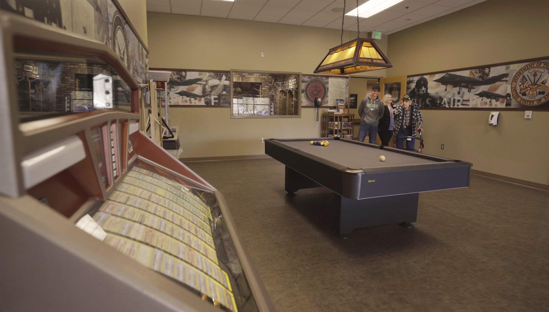A potential resident and his family visiting the pool hall during a tour of the North Dakota Veterans Home.